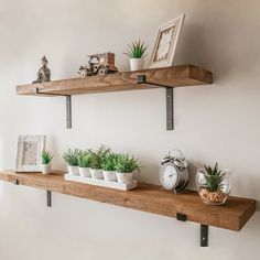 two wooden shelves with plants and pictures on them