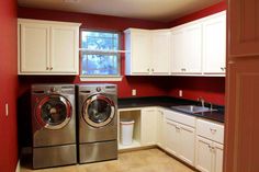 a washer and dryer in a kitchen with red walls