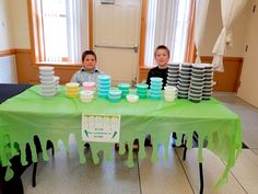 two young boys sitting at a table covered in green and blue frosted paper plates