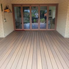 an empty patio with sliding glass doors and wood flooring