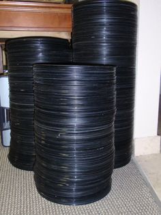 several black wires stacked on top of each other in front of a wooden table and chair