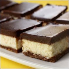 several pieces of cake sitting on top of a white plate next to a yellow table