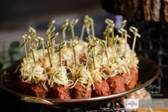 several skewered meatballs are on a platter