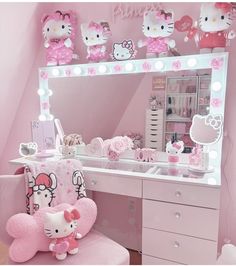 a hello kitty themed bedroom with pink furniture and accessories on the vanity area, including an illuminated mirror