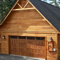 a large wooden garage with two doors and windows