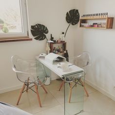 two clear chairs sit in front of a white desk