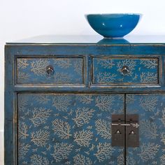 a blue cabinet with a bowl on top