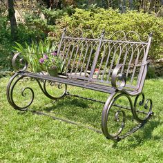 a metal bench sitting on top of a lush green field