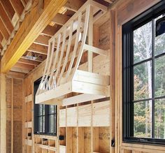 a bunk bed in the corner of a room with wooden walls and flooring that is being built