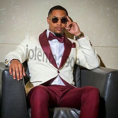 a man in a tuxedo sitting on a chair