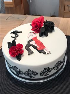 a white cake with black and red decorations on it's side, sitting on a table