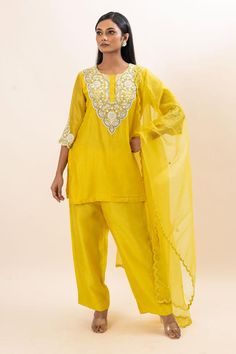 Yellow kurta with floral embroidered yoke and cuffs. Paired with a pant and dupatta.
Components: 3
Pattern: Hand Embroidery
Type Of Work: Floral, Chid, Pearls
Neckline: Round Neck
Sleeve Type: Three Quarter Sleeves
Fabric: Kurta: Chanderi, Pant: Bamber Silk, Dupatta: Organza, Lining: Mul Cotton
Color: Yellow
Other Details: 
Attached inner lining
Scallop trimmed dupatta
Occasion: Sangeet - Aza Fashions Designer Raw Silk Sets With Dori Work, Cotton Silk Palazzo Set With Gota Work, Semi-stitched Art Silk Palazzo Set With Chikankari Embroidery, Semi-stitched Slub Silk Sets With Dori Work, Designer Cotton Silk Palazzo Set For Navratri, Semi-stitched Gota Work Sets With Traditional Drape, Designer Wear Sets With Gota Work In Traditional Drape, Bollywood Cotton Silk Salwar Kameez With Gota Work, Festive Georgette Sets With Gota Work