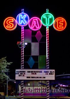 the sign for skate is lit up at night