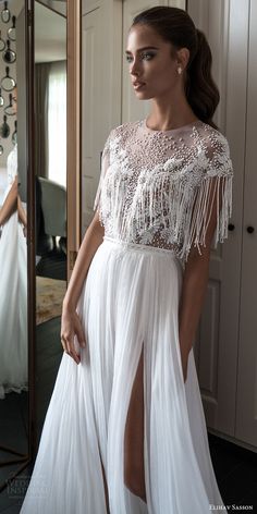 a woman standing in front of a mirror wearing a white dress