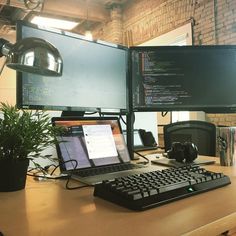 a desk with a laptop, monitor and keyboard on it