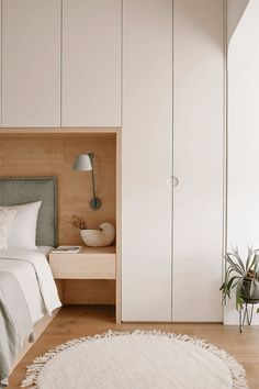 a bedroom with white walls and wooden flooring