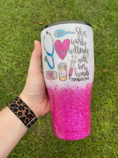 a hand holding a pink and white glittered coffee cup with words written on it