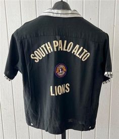 "Vintage 1960's Mr. Morts Short Sleeve Bowling Shirt.  Black in color with black and white striped trim at collar pocket tops and cuffs. Has \"South Palo Alto Lions\" on the back, w a Lions patch in the center. Has a patch on the left shoulder \"1967-1968\" ABC League Champ. 1 front pockets. Has a bowling pin on the pocket top. Size Medium.  Measures 48\" chest & 25\" length.  Great vintage condition." Black Collared Tops With Contrast Stripes, Retro Black Collared Shirt, Black Shirt With Striped Collar, Retro Black Camp Shirt With Camp Collar, Retro Black Cotton Camp Shirt, Vintage Black Shirt With Camp Collar, Vintage Collared Camp Shirt For Streetwear, Vintage Black Tops With Camp Collar, Streetwear Top With Striped Collar