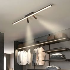 a closet with clothes hanging on shelves and lights above the closet area, along with other items