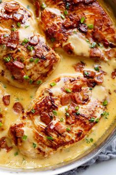 some meatballs covered in gravy and garnished with parmesan cheese