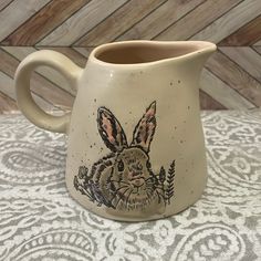 a ceramic mug with a rabbit painted on it