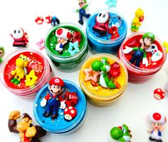 several small plastic toys are sitting on a table together, including mario and luigi's friends