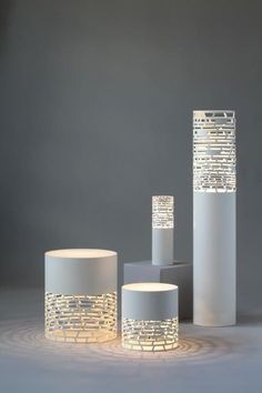 three white vases sitting next to each other on a table