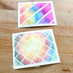 two watercolor stickers sitting on top of a wooden table