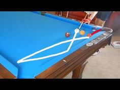 a blue pool table with balls on it and a racket sticking out of the top