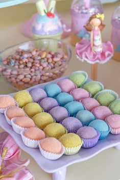 there are many different types of cupcakes on the table with other items in the background