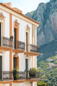 an apartment building with balconies and balcony railings in front of a mountain