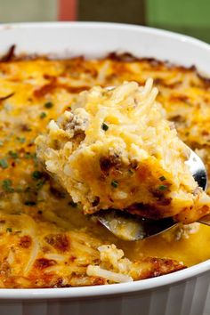 a close up of a spoon in a casserole dish with cheese and meat