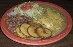 a red plate topped with lots of food on top of a wooden table