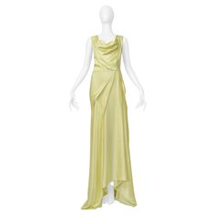 Resurrection is excited to offer a stunning vintage John Galliano lemon meringue yellow satin bias-cut evening gown featuring a plunging neckline with a cowl neckline, asymmetrical draping and pleating at the skirt, a side zipper, and a dramatic gown length. This is a classic and fine example of Galliano's famous evening downs. John Galliano Size 44 Fabric 72% Acetate, 28% Rayon Circa 2000s Excellent Vintage Condition - With Original Tags Authenticity Guaranteed Dramatic Gown, Chiffon Overlay Dress, Satin Evening Gown, Yellow Satin, Chiffon Overlay, Anna Wintour, Shopping Photography, Vintage Wardrobe, Lemon Meringue