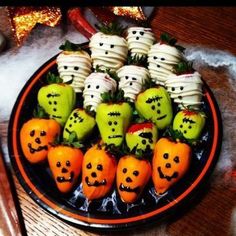 a plate full of halloween treats with faces and pumpkins on them, sitting on a table