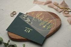 a couple of wedding cards sitting on top of a cutting board next to some scissors