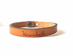 "Be Inspired all Day. Jewelry with meaning. Skinny Full Grain Leather Bracelet with Engraved with \"Unsinkable\". Makes a wonderful gift reminder to someone you love! Or choose a different word or customize one with your own words! (Choose custom & add your words in the personalization box.) This Classic style Leather Bracelet is perfect for stacking with each other or any bracelet! Made from Full Grain Leather from our local leather shop. We personally cut and engrave each bracelet. Closure is Custom Engraved Bracelet, Leather Engraved, Leather Engraving, Message Bracelet, Engraved Bracelet, With Meaning, Leather Conditioner, Personalized Bracelets, Gifts For My Sister