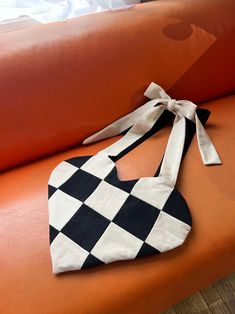 a black and white bag sitting on top of an orange couch