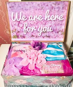 an open suitcase with pink flowers on the inside and we are here for you sign