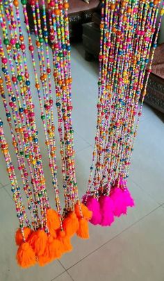 colorful beads and tassels hang from the ceiling in a room with tile flooring