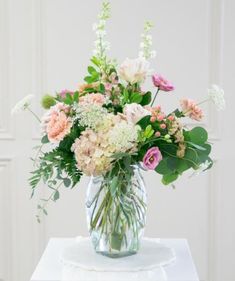 a vase filled with lots of flowers on top of a table