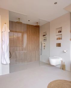 a bathroom with a glass shower door, toilet and standup shower in the corner