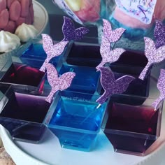 there are many small purple butterflies on the glass vases in front of each other