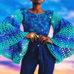 a woman wearing a blue crochet top with bell sleeves