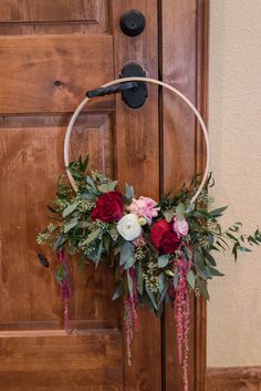 a hoop with flowers and greenery hanging from it