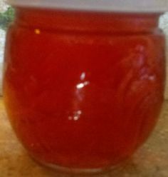 a jar filled with red liquid sitting on top of a counter next to a window