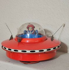 an old fashioned red radio with a glass dome on it's top and two antennas attached to the front