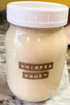 a glass jar filled with white liquid sitting on top of a counter