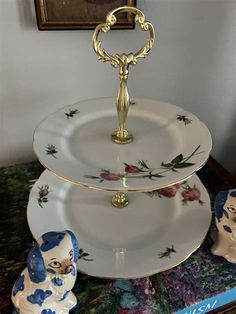 three tiered cake stand with two plates on top and an elephant figurine next to it