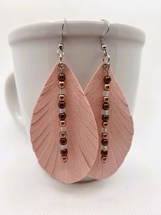 a pair of pink leather earrings with beads